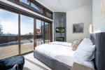 Bedroom 2 is framed by glass doors, bringing the beauty of the outdoors within.